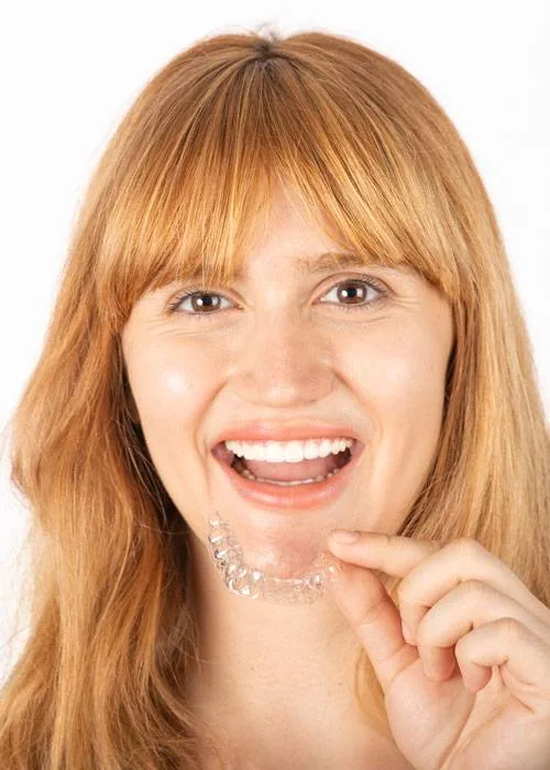 Beautiful smiling young woman with aligner.