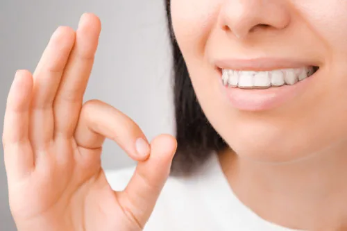 Happy woman with a perfect smile in transparent aligners on her