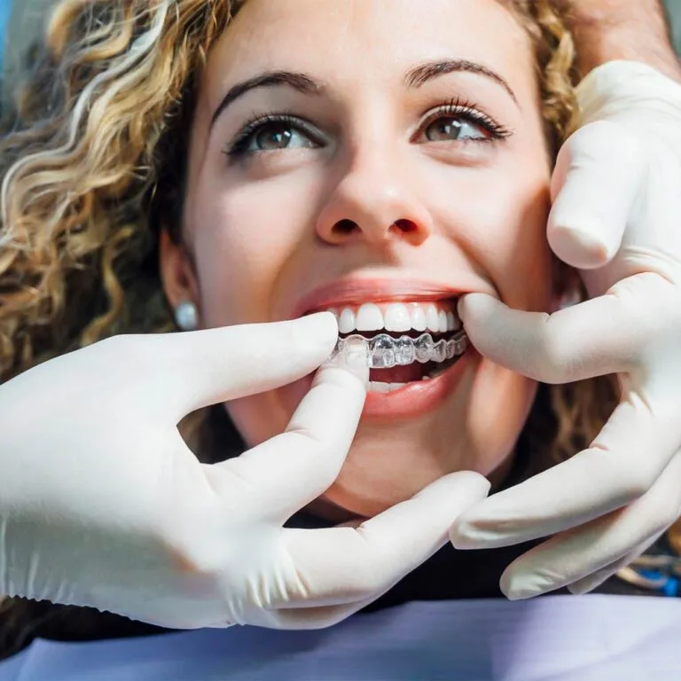 Dentist checking the fit of a clear aligner to ease discomfort with Invisalign